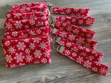 Red lanyards with white snowflake patterns on a wooden surface