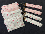 Set of fabric pouches with matching keychains on a dark background