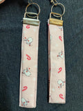 Two fabric keychains with festive designs on a dark surface