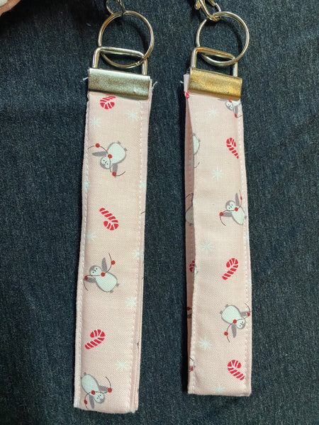 Two fabric keychains with festive designs on a dark surface