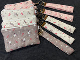 Set of fabric pouches with matching keychains on a dark background
